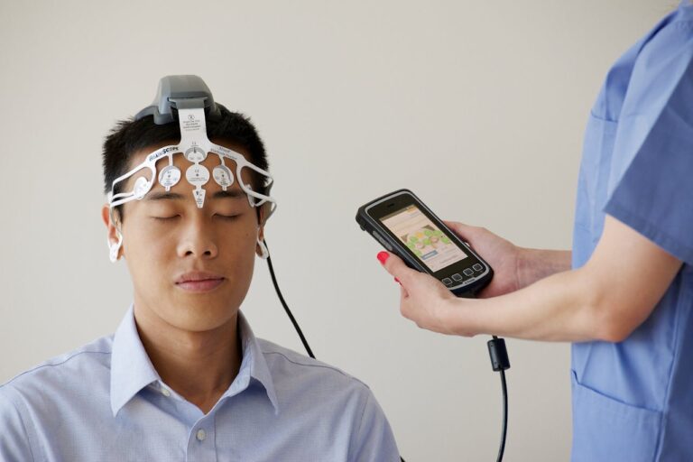 Healthcare professional conducting an EEG examination using a Brainscope device on a male patient.